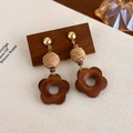 Macro detail of vintage floral wood earrings with woven straw texture and gold studs - Woven Ball Floral Tassel (27624C)