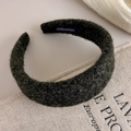 Detail of dark green textured fleece headband with handmade label on linen surface - Green