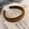 Close-up of handmade brown felt headband showing plush fiber texture and inner label - Coffee