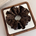 Detalle del coletero de leopardo con borde de cuero marrón oscuro en bandeja de madera - Estilo de Empalme de Cuero Leopardo (27666)