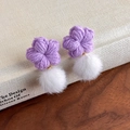Detail von lila gehäkelten Blumenohrringen mit weichen weißen Kunstpelz-Pompons - Lila Blume