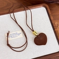 Detail van vintage hartvormige hanger aan bruin koord in een houten dienblad - Hartvormige Hanger Stijl (27698A)