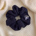 Dettaglio di un elastico per capelli in maglia nera con trama a treccia e cuore - Blu scuro