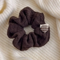 Detailed close-up of dark brown knit hair scrunchie with plaid heart and MBU label - Coffee