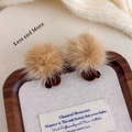 Detailed view of brown fur pom pom bear stud earrings displayed on a rustic wooden tray - Dark Coffee