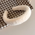Primer plano de diadema de piel de conejo sintética color crema con textura suave - Blanco