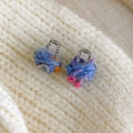 Detailed macro view of cute rainbow yarn bag earrings on cozy knit sweater background - Blue Multicolor