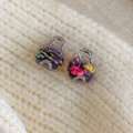Detailed close-up of handmade rainbow knit mini bag earrings with silver metal handles - Gray Multi-color