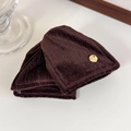 Detail of dark brown velvet hair clip with premium golden emblem on a clean beige surface - Brown Triangle Clip (27720E)