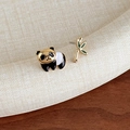 Macro view of asymmetrical panda and bamboo enamel studs on white fabric background - Asymmetric Panda Bamboo