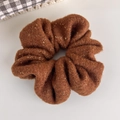 Vue détaillée du chouchou en tricot marron avec fils dorés brillants et texture douce - Orange