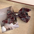 Détail d'un nœud papillon à carreaux de style britannique avec étiquette dorée sur plateau - Plaid en Laine