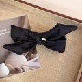 Détail d'un nœud papillon à pois noirs avec un logo carré en métal doré élégant - Noir Cœur Pois