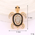 Broche de tortuga marina brillante en metal dorado con pedrería de colores en el caparazón - Blanco