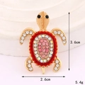 Broche de tortuga brillante con cristales rosas y metal dorado, medida 3,6cm por 2,6cm - Rojo