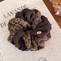Detail van luipaardprint scrunchie met gouden label op vintage boek achtergrond - 27772A Twist Stijl
