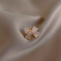 Élégante broche nœud doré sertie de cristaux sur fond en soie champagne - Doré