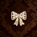 Close-up of golden bow brooch with sparkling crystals and elegant white pearls details - Gold