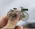 Close-up of a vintage bicycle brooch with green enamel finish and sparkling crystal wheels - Green