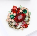 Detail showing vintage gold alloy flower brooch with red crystals and colorful rhinestones - Red