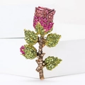 Elegante spilla a rosa vintage con cristalli rosa e foglie di strass verdi su sfondo bianco - Rosa