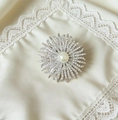 Detalle de un broche de girasol de lujo con una gran perla central y brillantes circonitas - Plateado