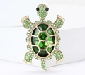 Detailed view of the turtle brooch featuring green crystal shell and gold plating finish - Green