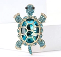 Macro detail of turtle brooch with blue crystals and glittering rhinestones on gold base - Lake Blue