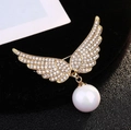 Elegant gold angel wing brooch with sparkling crystals and a white pearl drop on black velvet - Gold Angel Wing Pearl Style