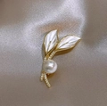 Elegante spilla a foglia dorata con perla e zirconi su sfondo di seta champagne - Forma di Foglia (X109633) / Oro