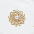 Elegante spilla a fiore dorata con una grande perla centrale e strass scintillanti - Oro