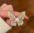 Elegante spilla a farfalla dorata con zirconi scintillanti e una grande perla bianca - Oro