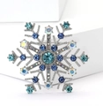 Détail d'une élégante broche flocon de neige avec cristaux bleus sur présentoir - Style Flocon de Neige Strass Bleu Argent Irisé / Bleu