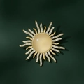 Broche de lujo en forma de sol con ópalo y cristales sobre fondo verde oscuro mate - Estilo de Resplandor Solar / Dorado