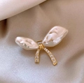 Broche nœud élégante avec perles baroques et cristaux sur un tissu en soie beige - Doré