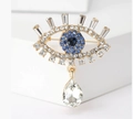 Broche Ojo del Mal con cristales azules y colgante de gota en base dorada - Azul