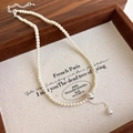 Detailed close-up of a pearl necklace with silver metal ball pendant on jewelry tray - Silver Style (27231B)