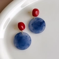 Detail van rode kralen en blauw gemarmerde hars oorbellen met gouden accenten - Ronde Knopjes (27259B) / Rood Blauw