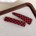 Close-up of red and black checkered fabric hair clips set on a rustic wooden tray - Red and Black Checkered