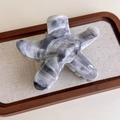 Detail of starfish hair claw featuring grey ink marble texture on elegant linen tray - Pentagram (27267G)