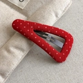 Detailed macro view of a red fabric hair clip with white polka dots and a black metal clip - Red Style (27299B)
