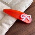 Détail de la pince à cheveux artisanale en acétate orange avec texte France doré - Rouge Orangé