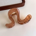 Close-up of brown amber pattern wave hair claw with a durable gold metal spring - Transparent Coffee Irregular Wave (27315B)