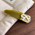 Close-up of green acetate hair clip with white bow and France Handmade logo detail - Grass Green