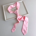 Nahaufnahme einer rosa Satinkrawatte mit roten Punkten und Fuchsmuster in einem Tablett - Rosa Hund
