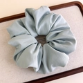 Detailed view of light blue satin fabric hair scrunchie with elegant pleated texture - Light Green