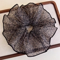Detail eines Haargummis mit Leopardenmuster und Netzgewebe auf einem Holztablett - Schwarz Eingefasster Stil (27333B)
