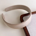 Close-up of cream leather headband with orange hand-stitched detailing and fine texture - Beige