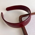 Detailed view of burgundy faux leather headband with decorative orange stitching - Red