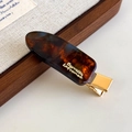 Nahaufnahme der Schildpatt-Haarklammer aus Acetat mit goldener Metallklammer und Logo - Mokkablan